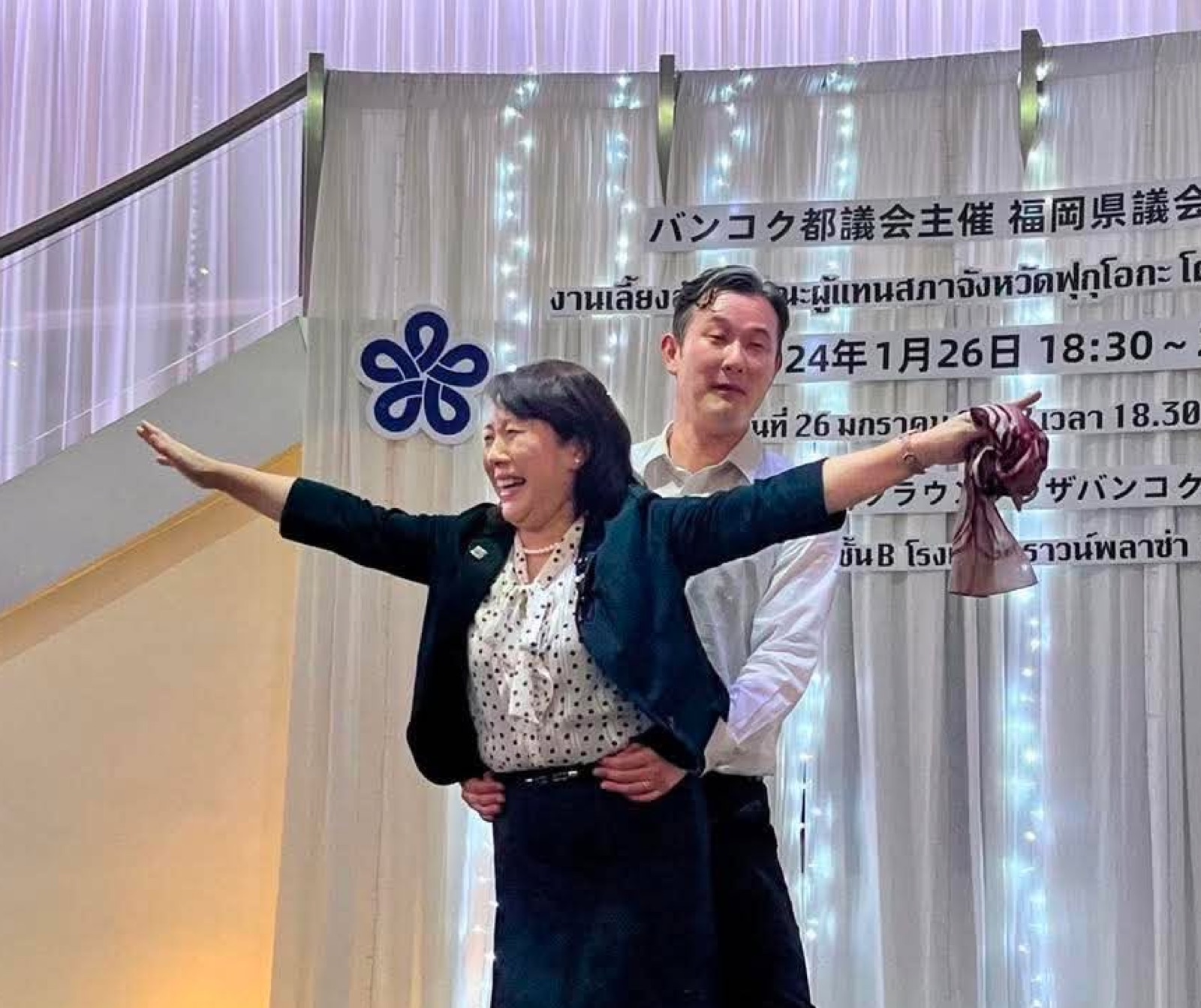 舞台に上がった豊福るみ子県議(遠賀郡/当時 民主県政県議団)と林泰輔県議(朝倉市・朝倉郡/自民党県議団)